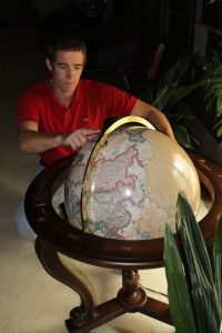 Justing Fisch examining a globe